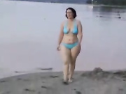 Очень форменная русская женщина раздевается на пляже